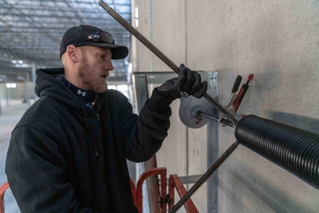 Mission GDS technician winding a garage door torsion spring